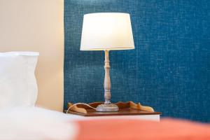 a lamp sitting on a table next to a bed at Lido Mar - Hotels area in Funchal +24 photos