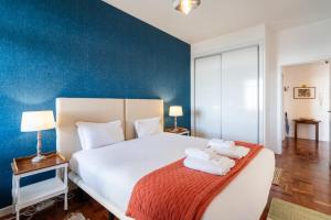 a bedroom with a large white bed with towels on it at Lido Mar - Hotels area in Funchal