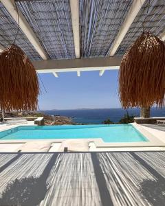 a swimming pool with a view of the ocean at villa EYEONSUNSET - MAGICAL PLACE -PRIVATE pool -SEA and SUNSET VIEW -NO WIND - in Mikonos
