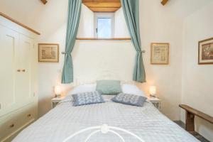a bedroom with a white bed with two blue pillows at Y Sied in Newport