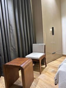 a chair and a stool in a room with a window at SAC HOUSE Sector 41 in Gurgaon