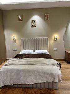 a bedroom with a large bed with two lights on the wall at SAC HOUSE Sector 41 in Gurgaon