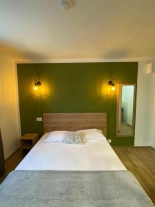 a bedroom with a large bed with a green wall at Hotel U Catagnu in San-Nicolao +10 photos