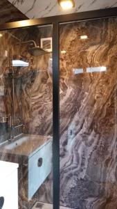 a bathroom with a stone wall with a bath tub at ARA Caravan Villa in Bedugul +25 photos