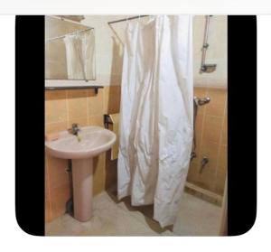 a bathroom with a sink and a shower curtain at Dar Khnata in Temara