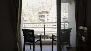 two chairs sitting in front of a window at Rams Inn in Krishnagiri