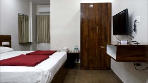a hotel room with a bed and a television at Rams Inn in Krishnagiri