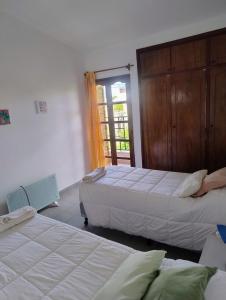 a bedroom with two beds and a door to a balcony at Mirador de Nieva in San Salvador de Jujuy
