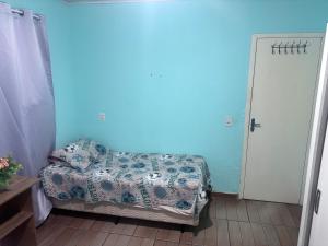 a bedroom with a bed and a blue wall at Casa aconchegante in Palhoça