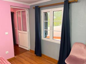 a room with blue curtains and a window at Casa Levada Explorer - Cozy Nights & Easy Meals in Santana +30 photos