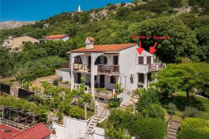 an aerial view of a house with a mountain in the background at Double Rooms Jasna with Sea View in Baška