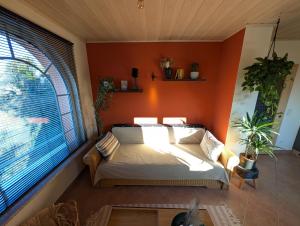 a bedroom with an orange wall with a bed and a window at Appartement Sonnenschein in Böhl-Iggelheim +1 photo