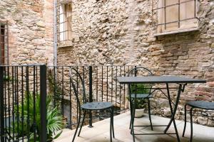 a table and chairs on a balcony with a brick wall at San Giacomo Suites in Città di Castello