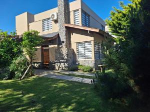 a house with a grass yard in front of it at DUPLEX AL SUR in Villa Gesell