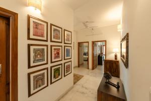 a hallway with a bunch of framed pictures on the wall at Art KOTHI Gurgaon in Gurgaon