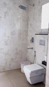 a bathroom with a white toilet and a shower at Rams Inn in Krishnagiri