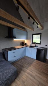 a large kitchen with white cabinets and a window at Domek na Ogrodowej in Tylicz
