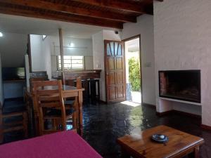 a living room with a table and a fireplace at DUPLEX AL SUR in Villa Gesell