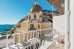 a balcony with a view of a church and the ocean at Villa La Tartana in Positano +54 photos