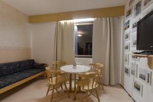 a living room with a table and chairs and a couch at Hotel & Resort Sallavalkea in Salla