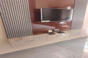 a flat screen tv sitting on top of a entertainment center at Dreamscape Rooms - Yelagiri in Yelagiri