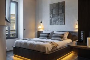 a bedroom with a large bed with two pillows at WABI-SABI Hôtel Lorrain - Self Check-in in Nice