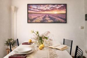 a dining room table with a painting on the wall at Lake Como Lilla Apartment in Oliveto Lario