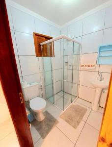 a bathroom with a shower and a toilet and a sink at Casa Dourada PIPA RN - Sobrado 2 quartos in Pipa +18 photos