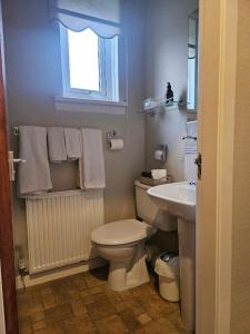 a bathroom with a white toilet and a sink at Whitecroft B&B in Edinburgh +13 photos