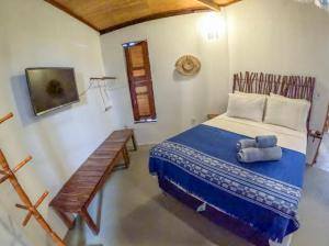 a bedroom with a bed and a bench in it at Casa do Francês in Japaratinga