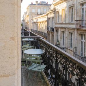 a table and chairs on a balcony of a building at Grand Hotel Francais in Bordeaux