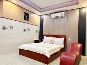 a bedroom with a bed and a red chair at Thanh Cong Hotel in Sa Ðéc +30 photos