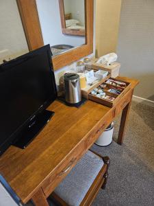 a wooden desk with a television and a mirror at Whitecroft B&B in Edinburgh