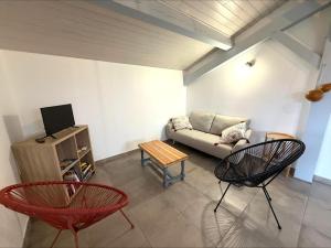 a living room with a couch and two chairs at Pierron in Linxe