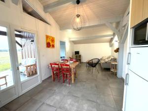 a living room with a table and chairs and a kitchen at Pierron in Linxe