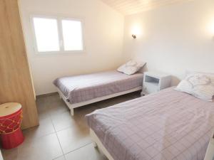 a bedroom with two beds and a window at Pierron in Linxe