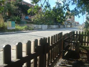 a fence on the side of a road at Chalés no centro de Bombinhas in Bombinhas