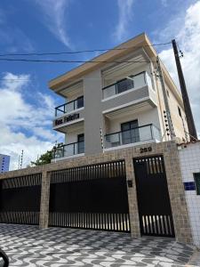a building with two garage doors in front of it at Casa 3 dormitórios 100 metros da praia in Praia Grande