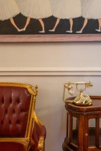 a chair and a picture on the wall next to a table at Rustaveli Hotel in Tbilisi City