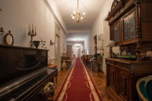 a hallway with a piano and a long red carpet at Rustaveli Hotel in Tbilisi City