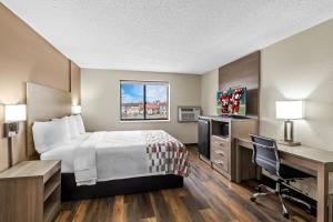 a hotel room with a bed and a desk and a computer at Red Roof Inn Ames in Ames