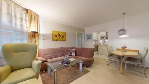 a living room with a couch and a table at FeWo direkt am Strand , mit Balkon und seitlichem Meerblick, Haus Strelasund, Binz in Binz