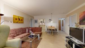 a living room with a couch and a table at FeWo direkt am Strand , mit Balkon und seitlichem Meerblick, Haus Strelasund, Binz in Binz