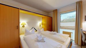 a hotel room with two beds and a large window at FeWo direkt am Strand , mit Balkon und seitlichem Meerblick, Haus Strelasund, Binz in Binz