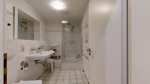 a white bathroom with a sink and a shower at FeWo direkt am Strand , mit Balkon und seitlichem Meerblick, Haus Strelasund, Binz in Binz +18 photos