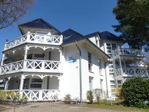 a white building with a black roof at FeWo direkt am Strand , mit Balkon und seitlichem Meerblick, Haus Strelasund, Binz in Binz