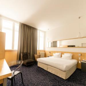 a hotel room with a bed and a chair at Grand Hotel Francais in Bordeaux +75 photos