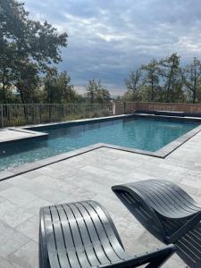 a swimming pool with a bench and a chair in it at Cabane de Combe Falce in Salignac Eyvigues