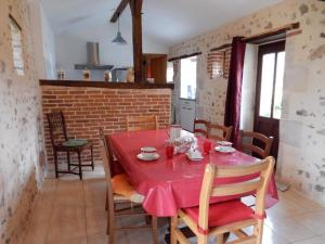 a dining room with a red table and chairs at Gîte de la vacherie in Port de Salles