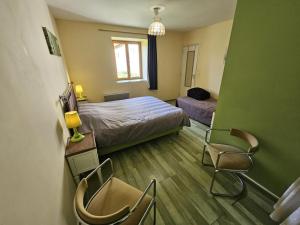 a bedroom with a bed and two chairs in it at Gîte de la vacherie in Port de Salles